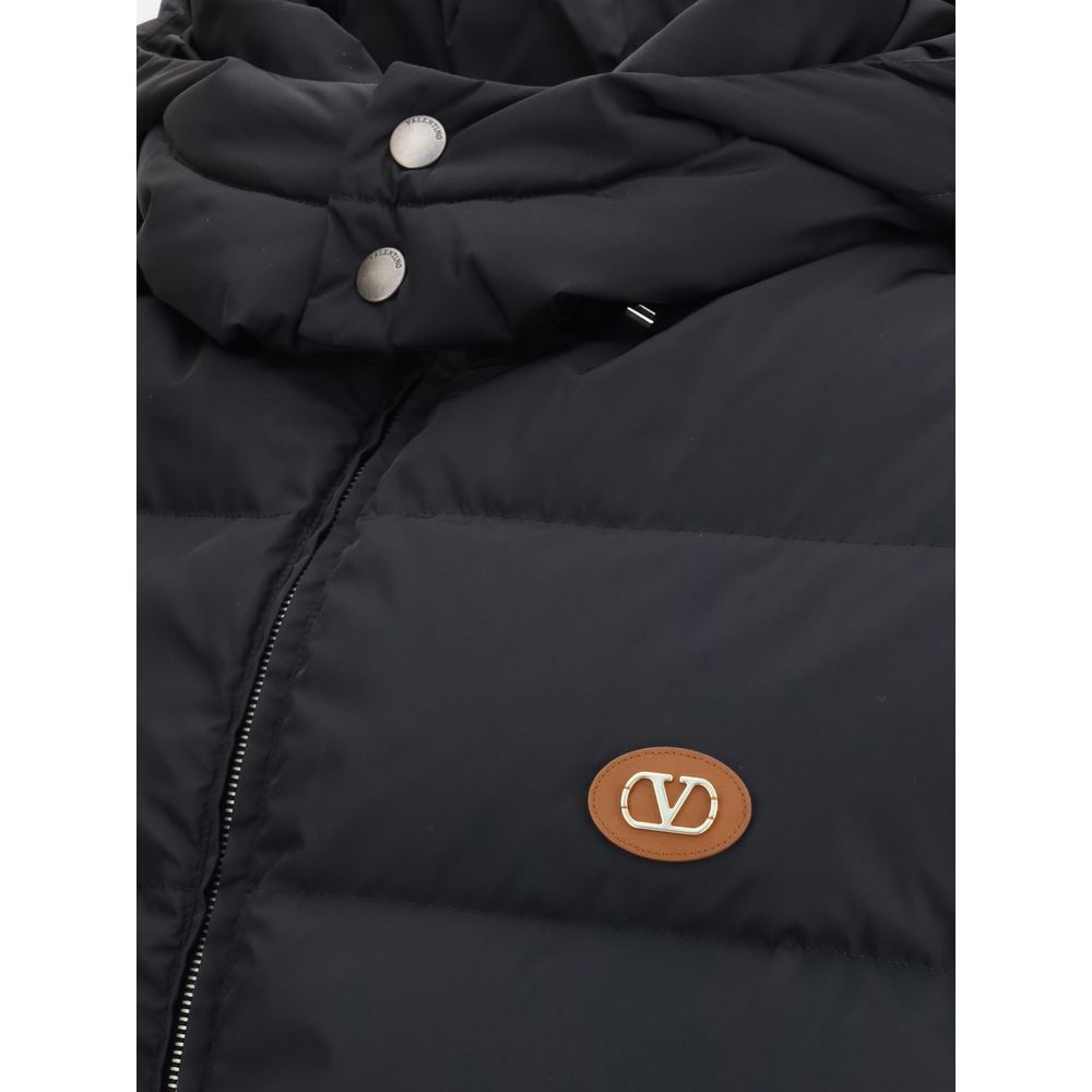Valentino Black Goose Down Sleveless Jacket with leather logo patch and quilted design featuring removable hood and zipper closure.